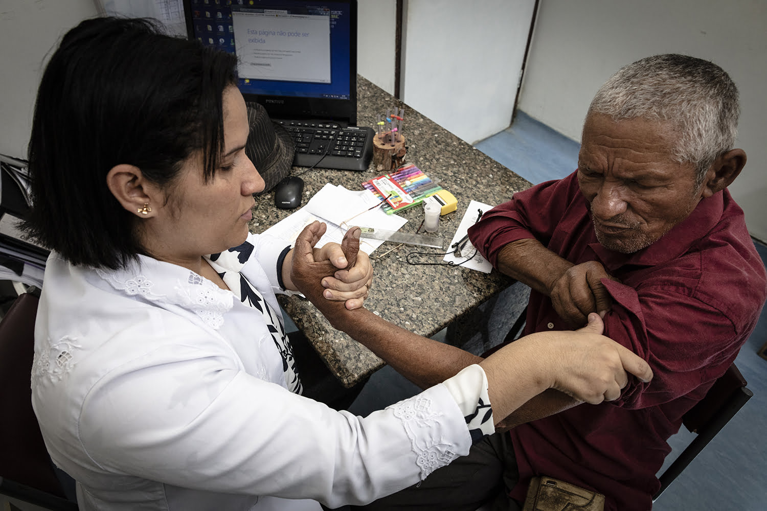Dr. Fabiana Amorin, at Otávio de Freitas Hospital, examining Antonio José de Souza's nerves and strengh.